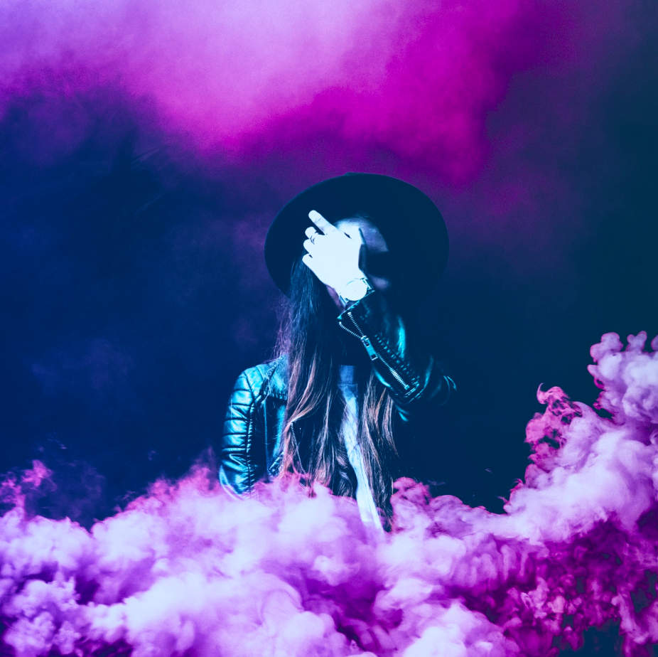 https://fund.garden/images/Eine Person mit Hut, eingehüllt in dichten, violetten Rauch